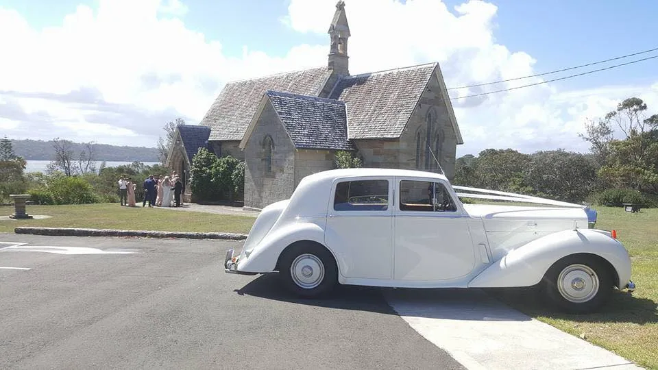Long white stretch wedding car from distance