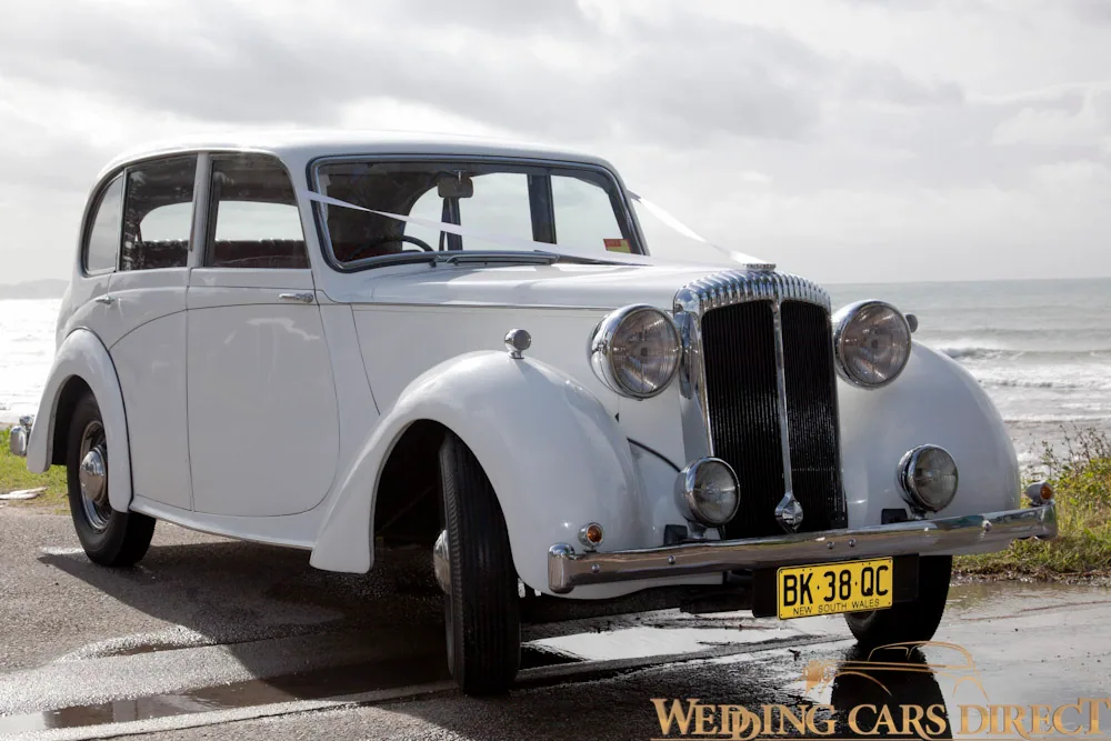 White Chrysler wedding car near beach