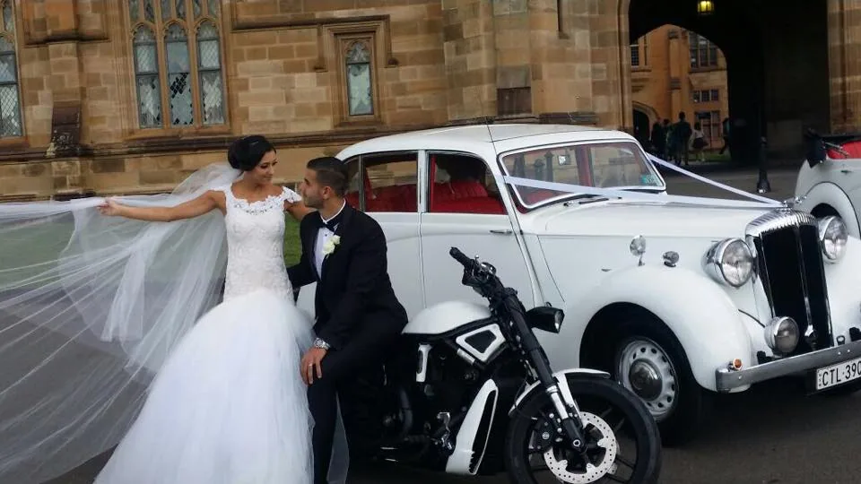 White Chrysler wedding car with motorbike