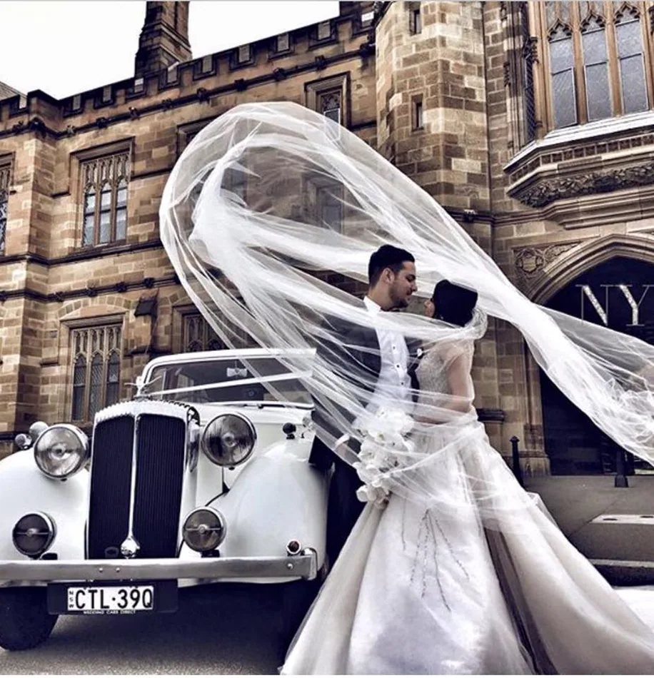 Bride veil beside white Chrysler wedding car