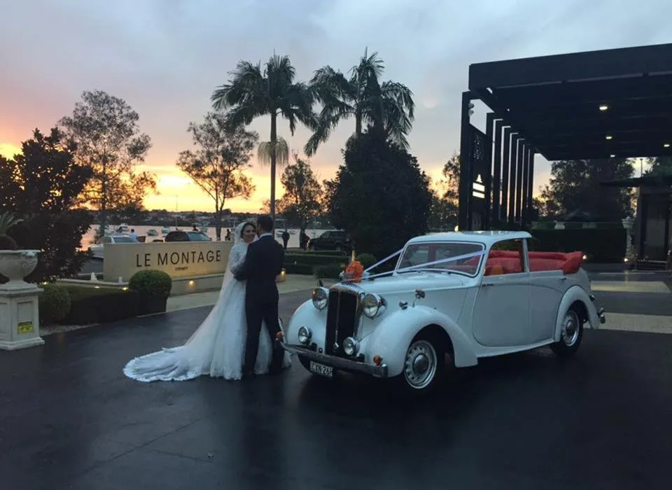 White convertible wedding car with bridal couple