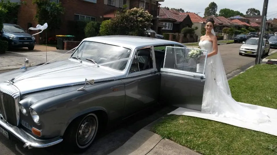 Bride beside silver Daimler wedding car