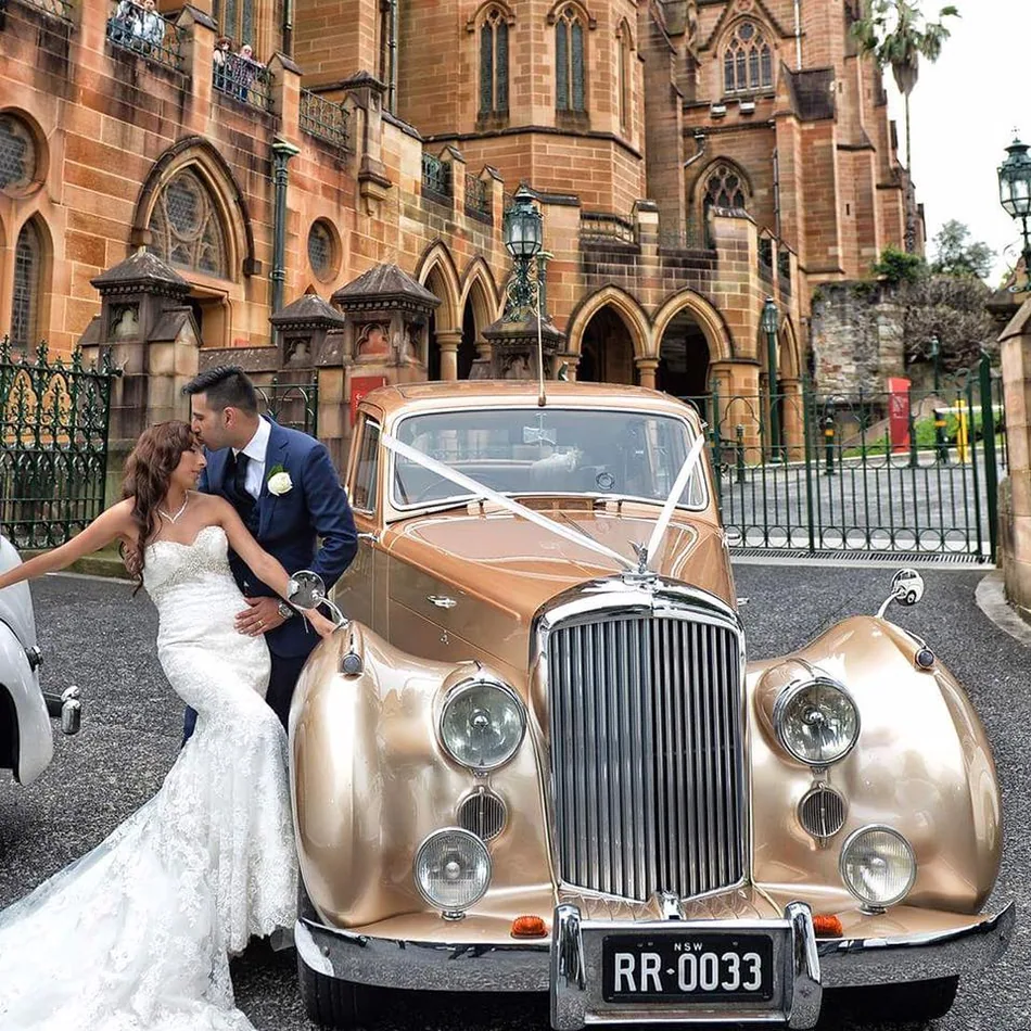 Wedding couple with gold Rolls-Royce Juliet